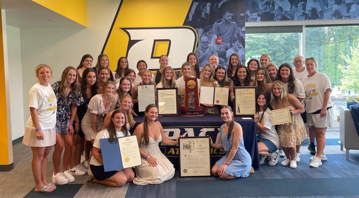 Pace University National Champion Women's Lacrosse team posing with awards