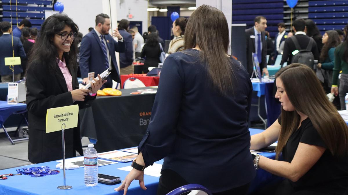 Pace university student speaking to employers at a job fair