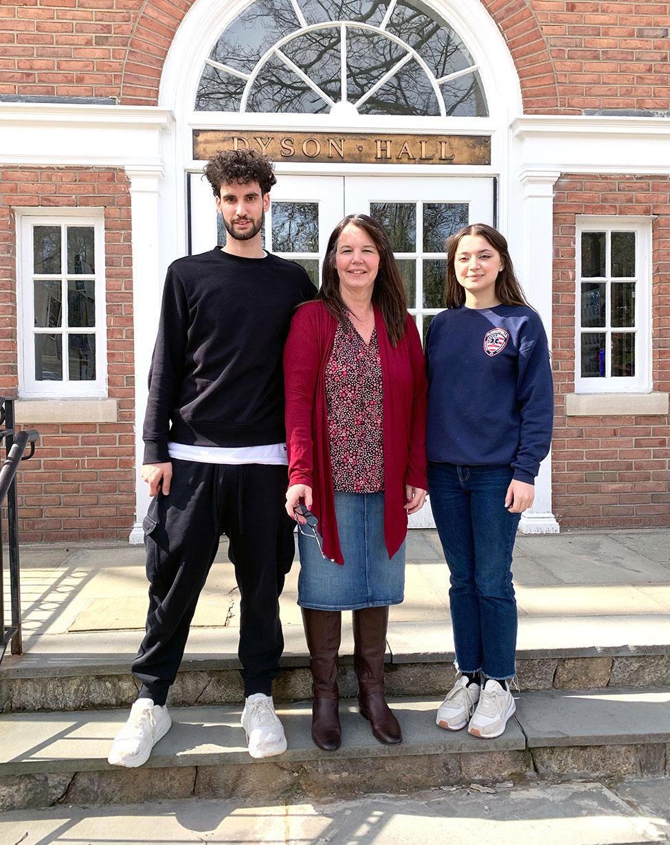 Pace University's Biology Professor Nancy Krucher standing on the steps in front of Dyson Hall with students Michael Feretti and Anastasiia Vaska who assisted in cancer treatment resistance research