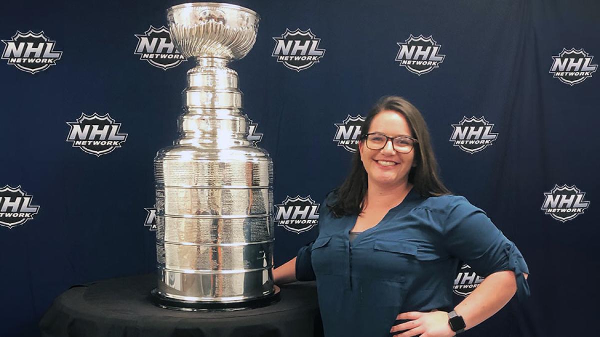Pace University's Media, Communications, and Visual Arts alum Kelly Writenour posing with the NHL Stanley Cup