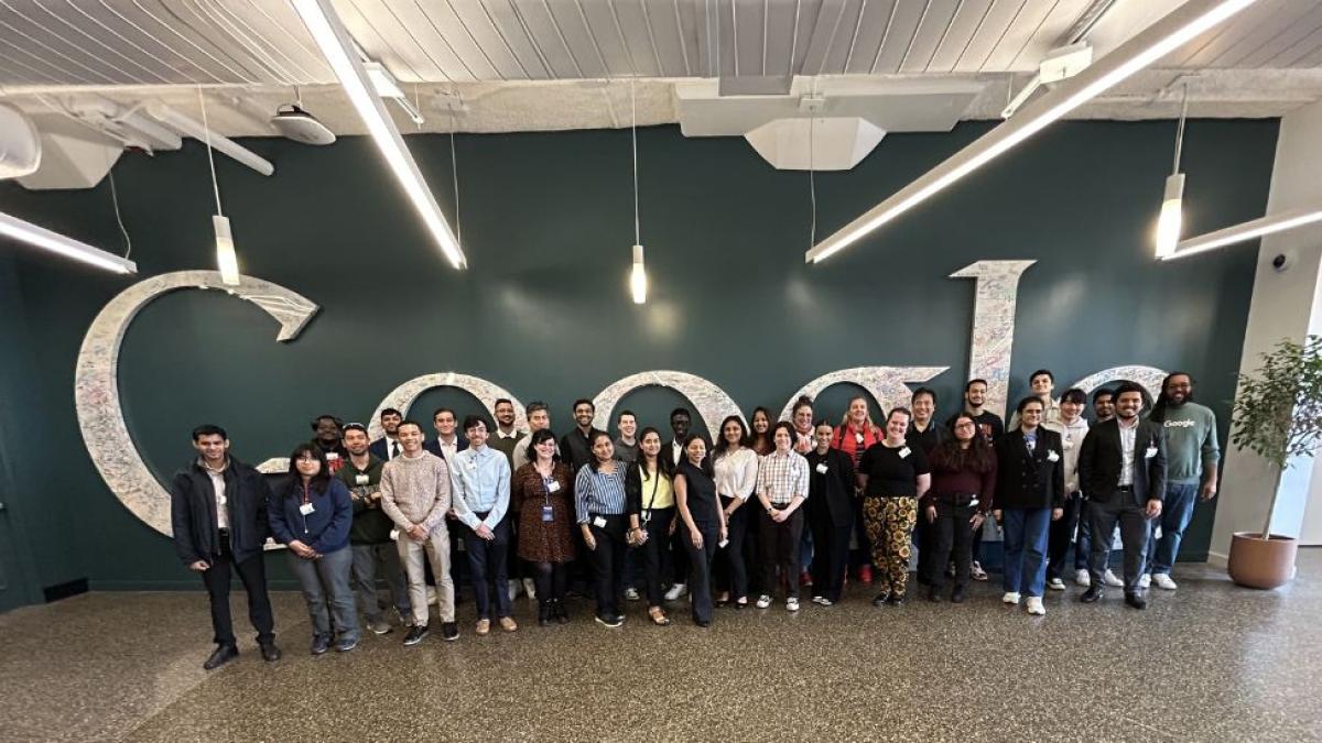 Pace Seidenberg students, faculty, and staff posing in front of the Google logo at the Google New York City office.