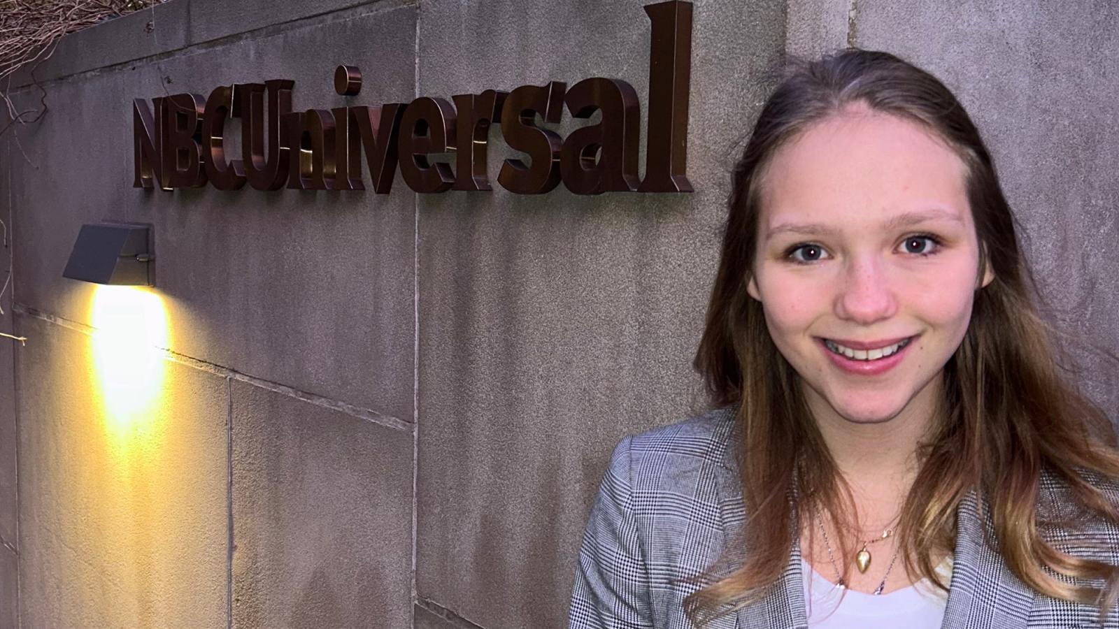 Pace student Amber Brouwer stands in front of the NBCUniversal sign