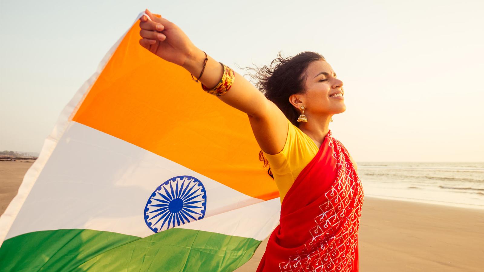 Woman in a sari holding the flag of India