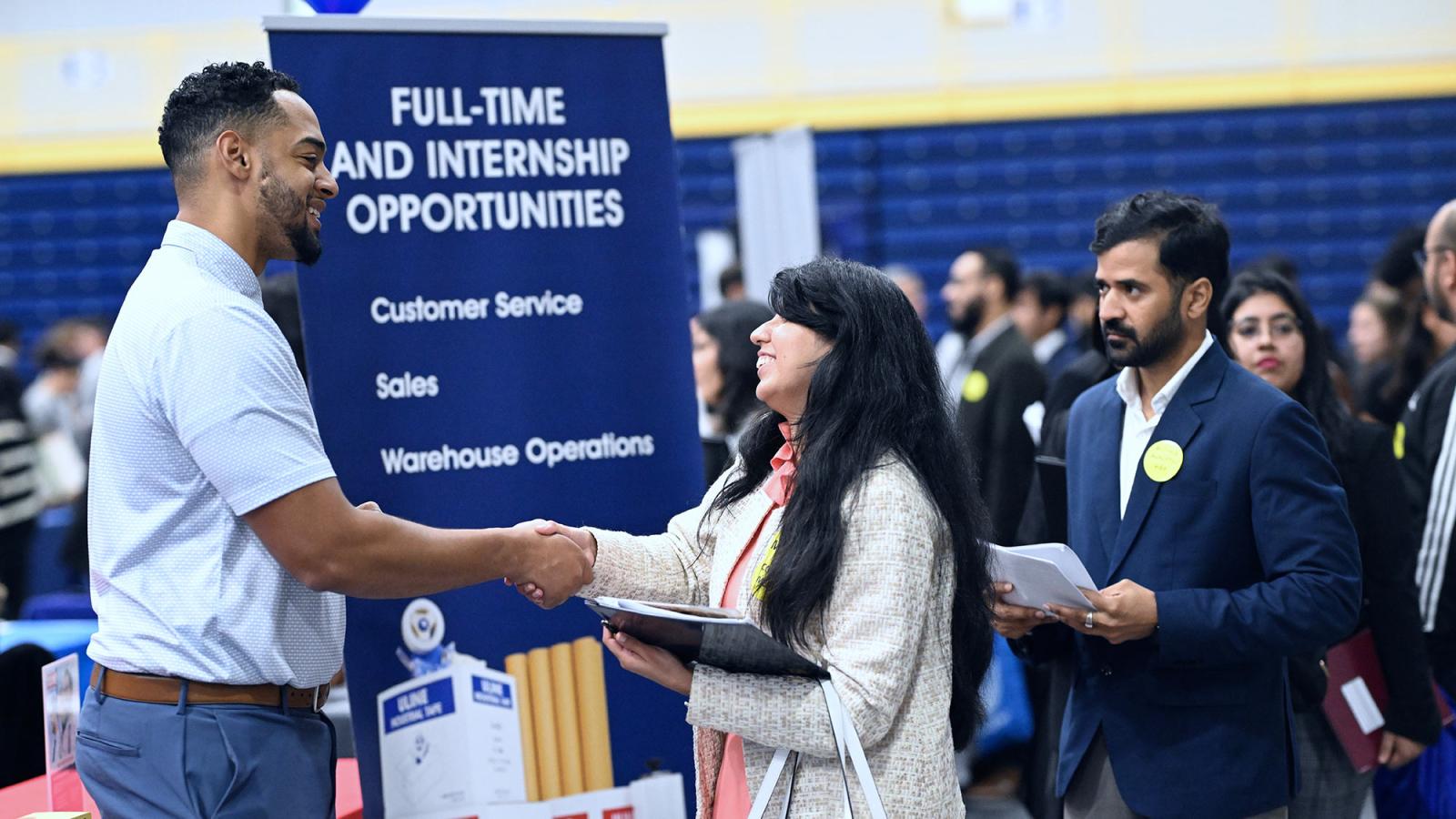 A Pace student shakes hands with someone at a Pace Career fair