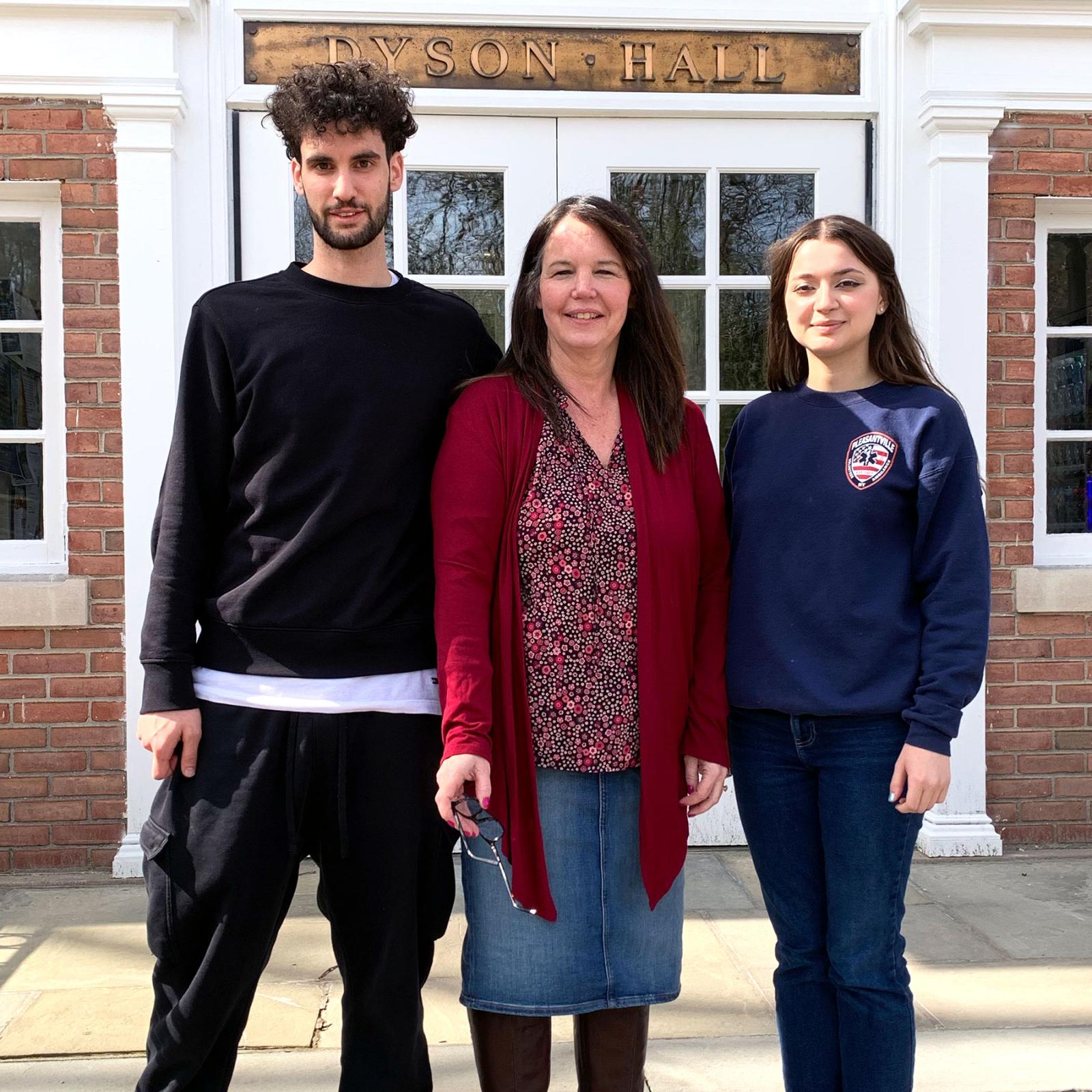 Pace University's Biology Professor Nancy Krucher standing on the steps in front of Dyson Hall with students Michael Feretti and Anastasiia Vaska who assisted in cancer treatment resistance research