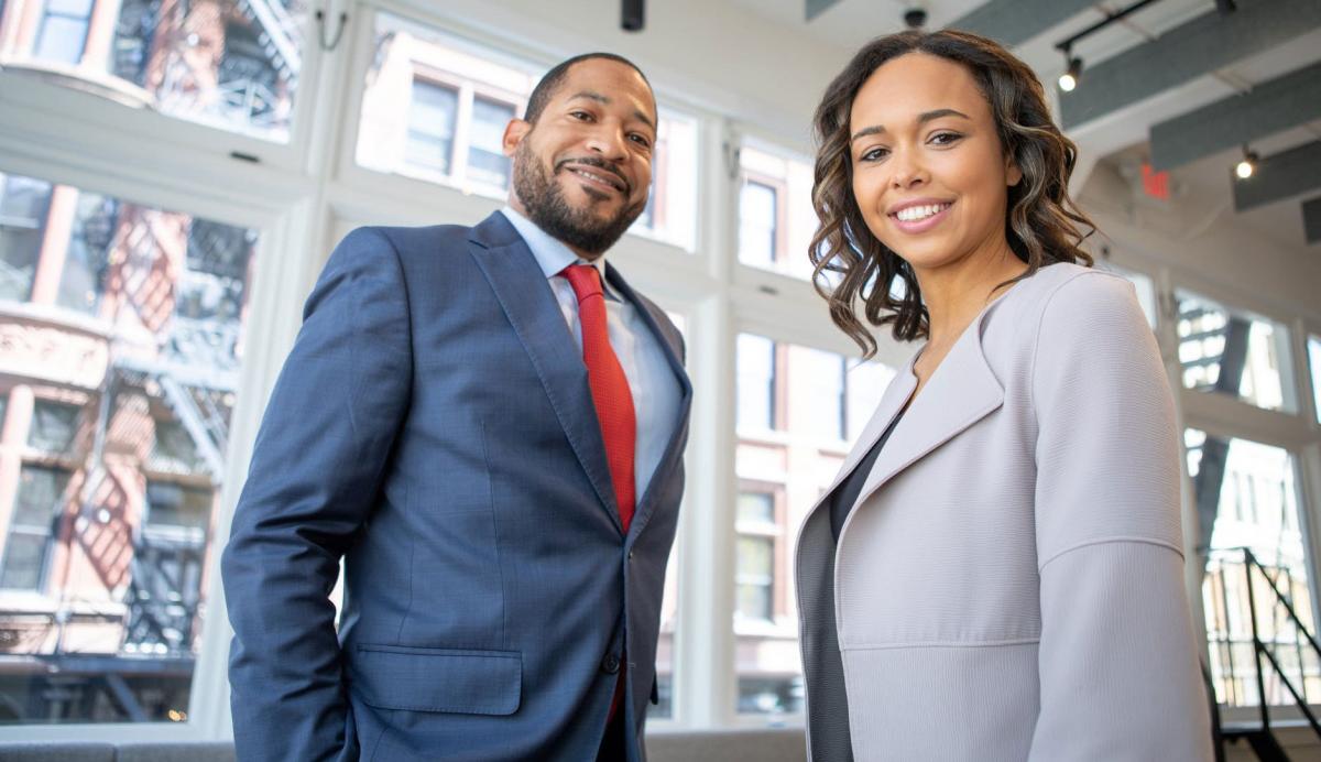 Students dressed in business attire smiling at the camera.