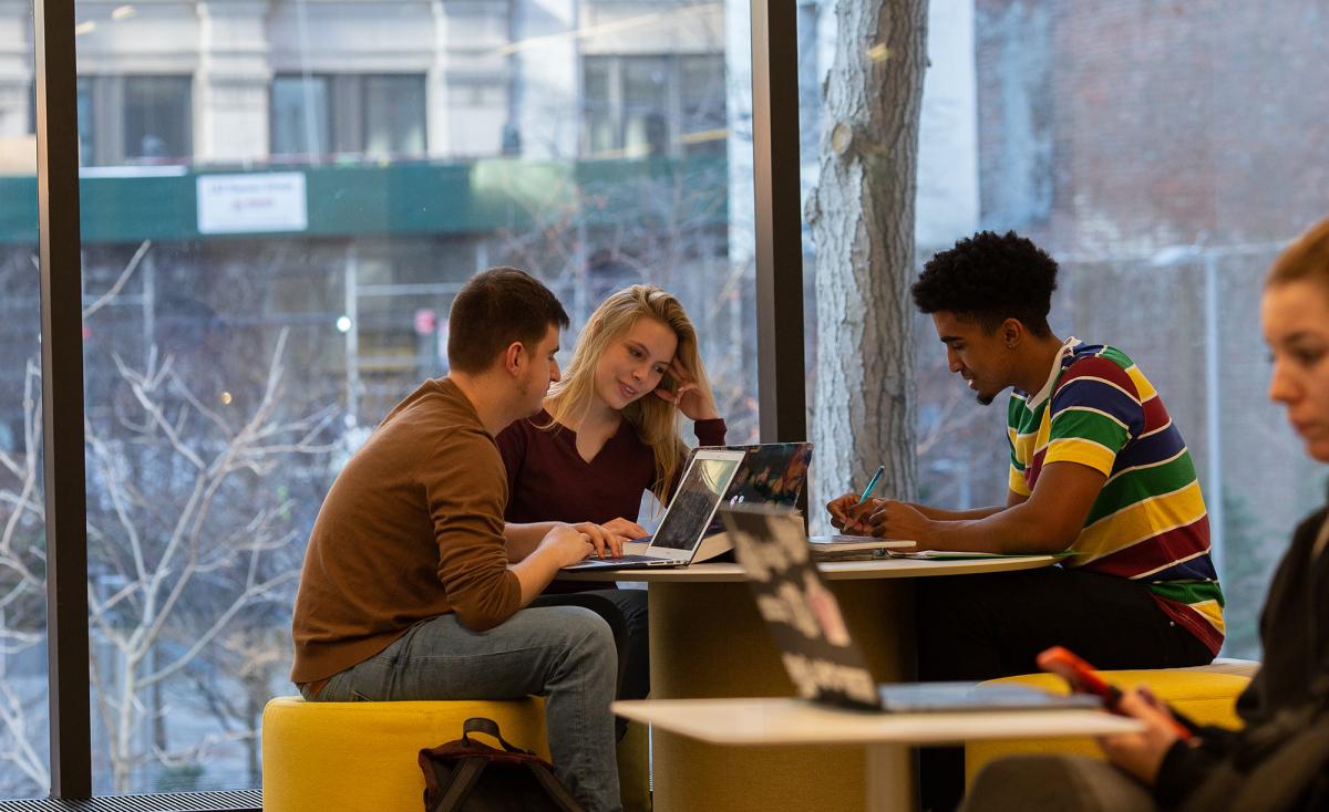 Students sitting at a desk studying together.