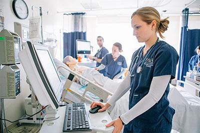 young woman in scrubs at computer