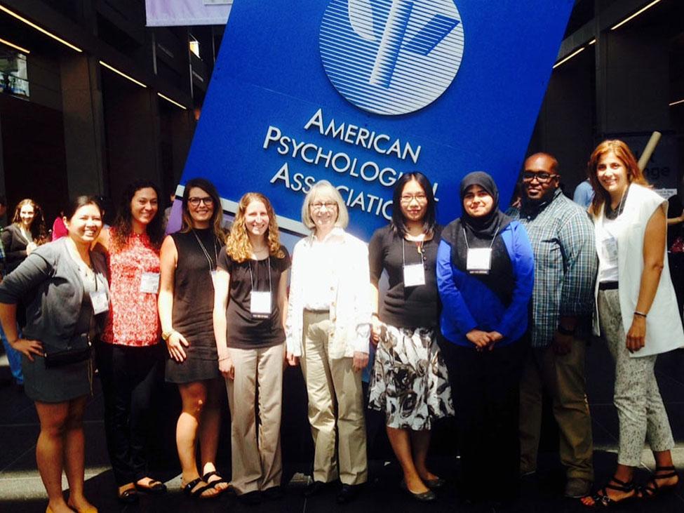 Seven female and one male students standing with Dr. Barbara Mowder at the American Psychological Association (APA) conference in Washington, DC. 