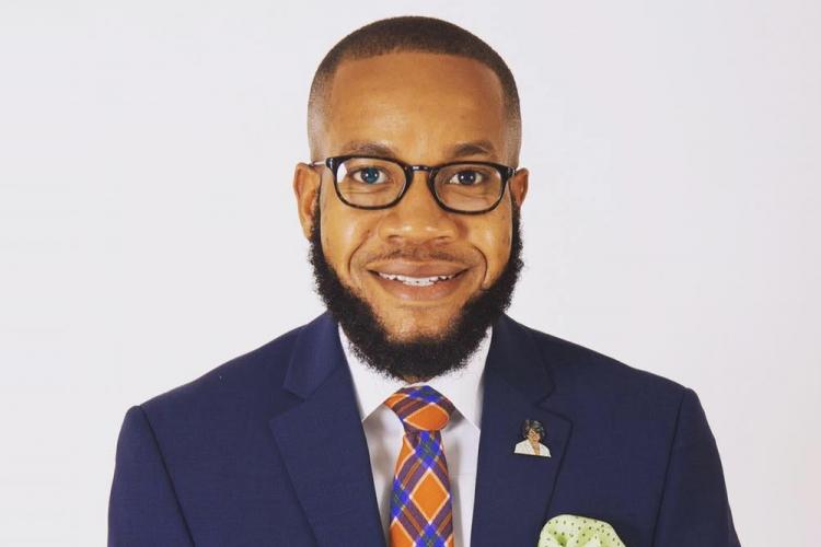 black man with a beard in a blue suit