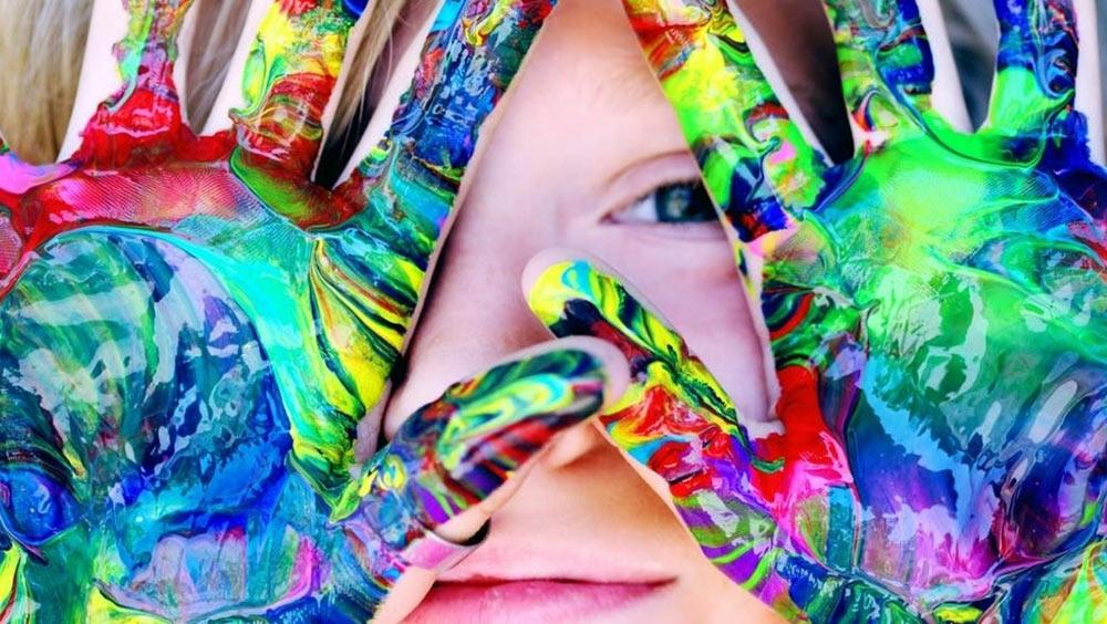 Child showing their painted hands to the camera.