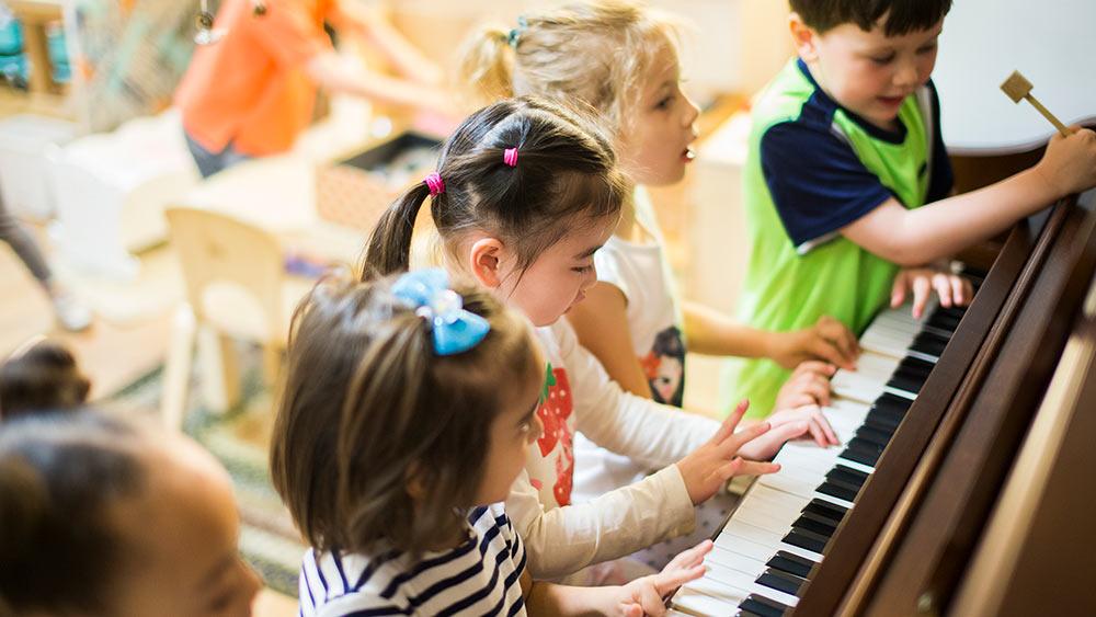 Group of children playing the piano.
