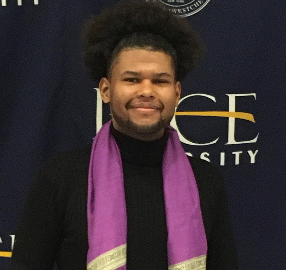 Ramón Emilio Fernández, PhD, smiles at the camera, in front of a Pace logo background