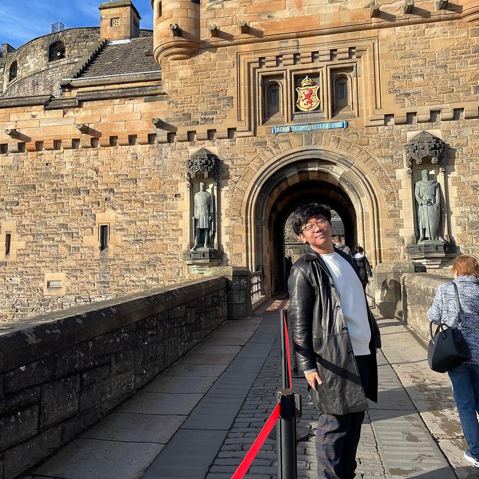 Pace University student standing in front of a Scottish castle