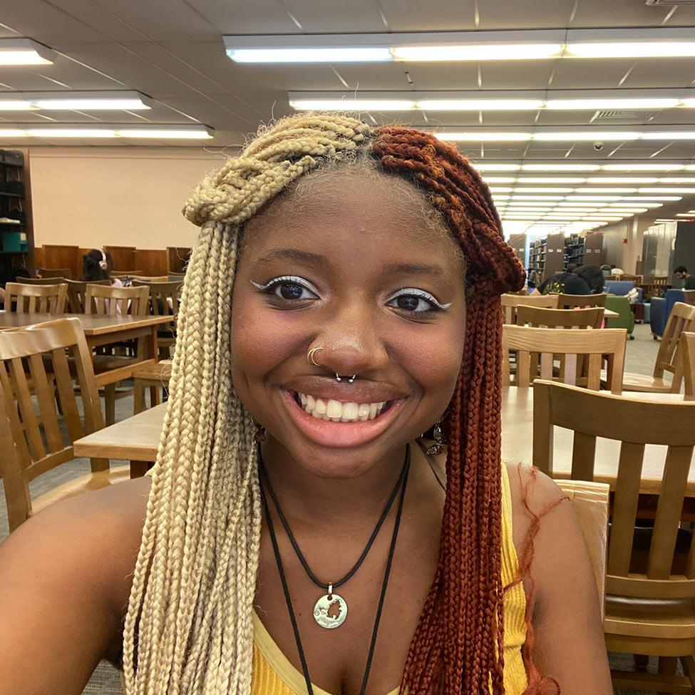 young woman smiling at camera in library