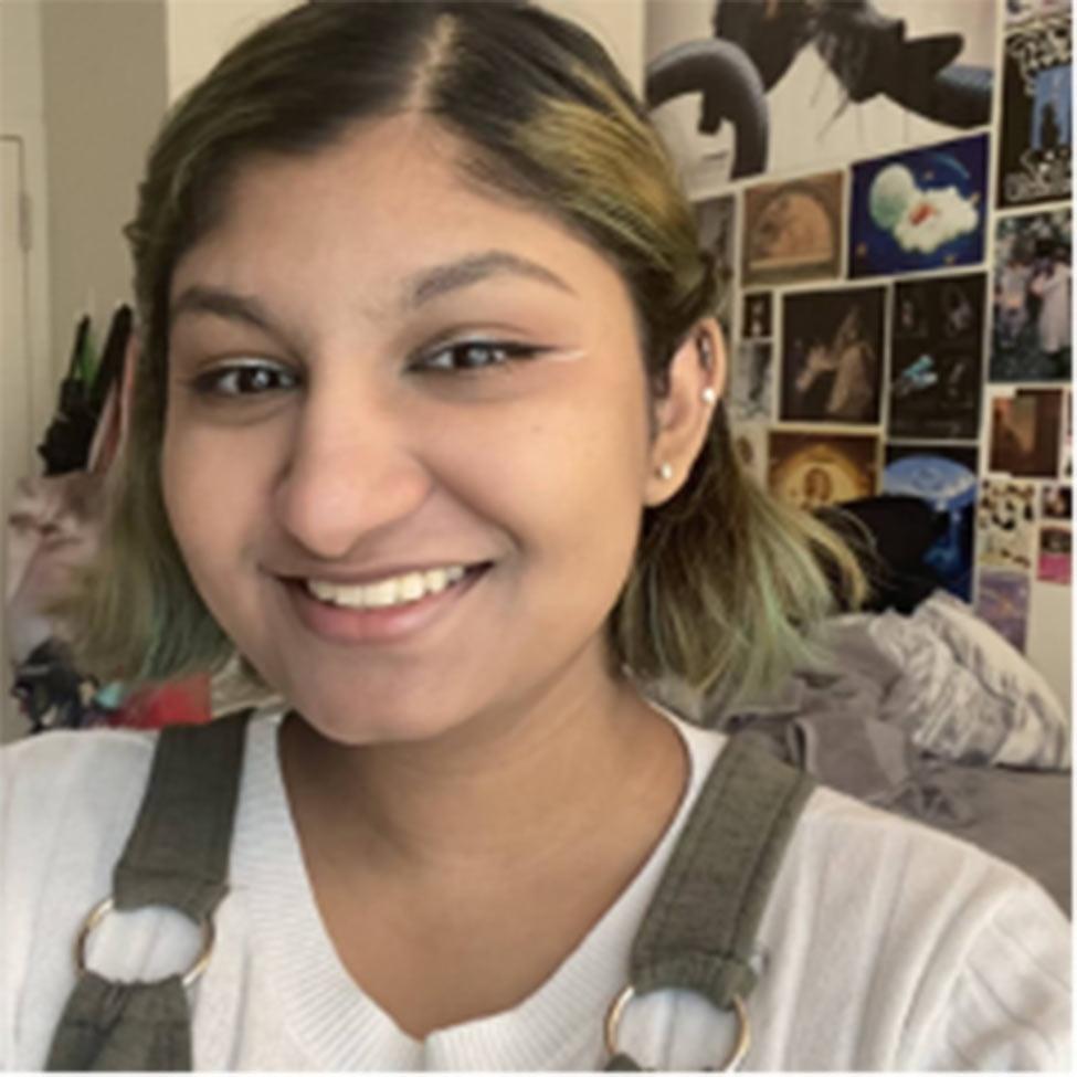 Portrait of Samara Durgadin wearing a white shirt with olive green overalls