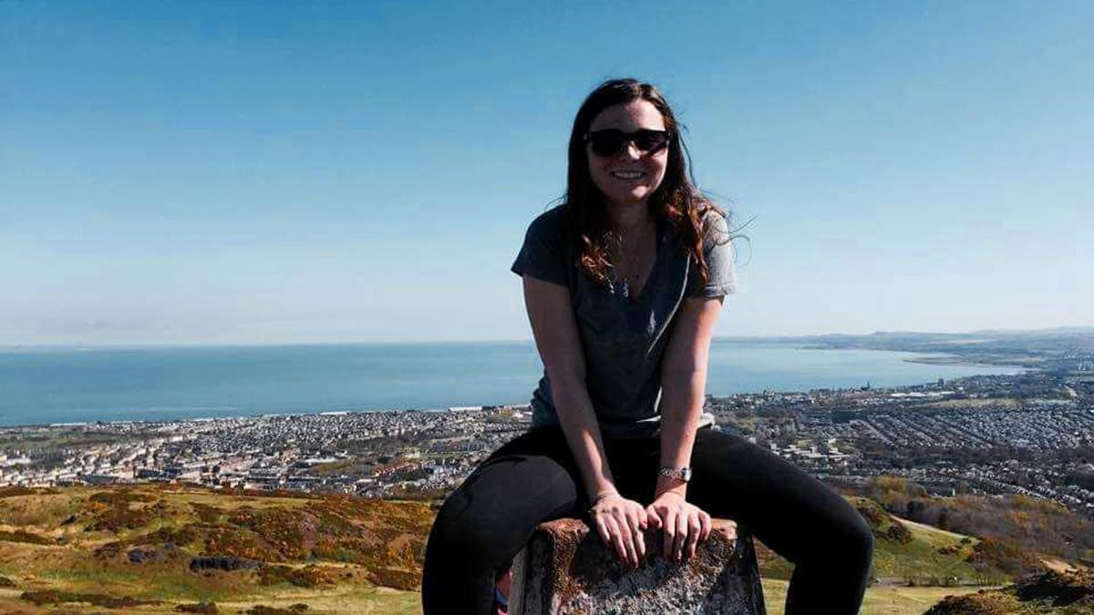 Lubin student Wendy Smith '16 sitting on a rock at the top of a hill during her semester abroad in Ireland