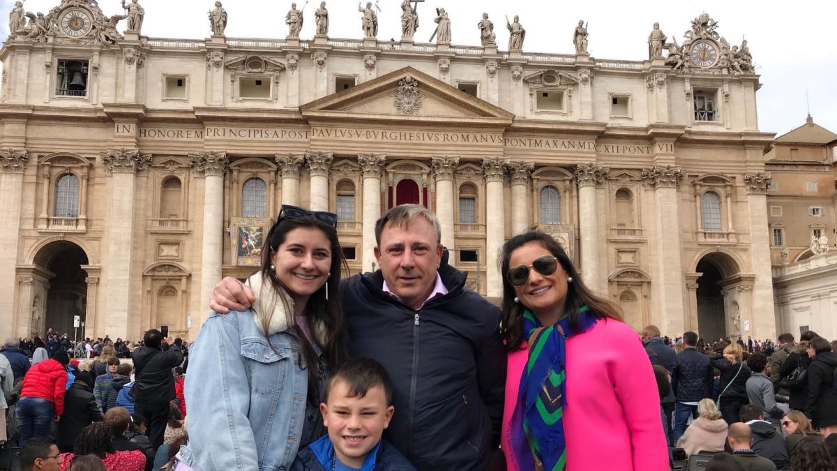 Lubin student Olena Hauser'20 standing with two adult friends and a child in front of an historic building during her semester abroad in Italy