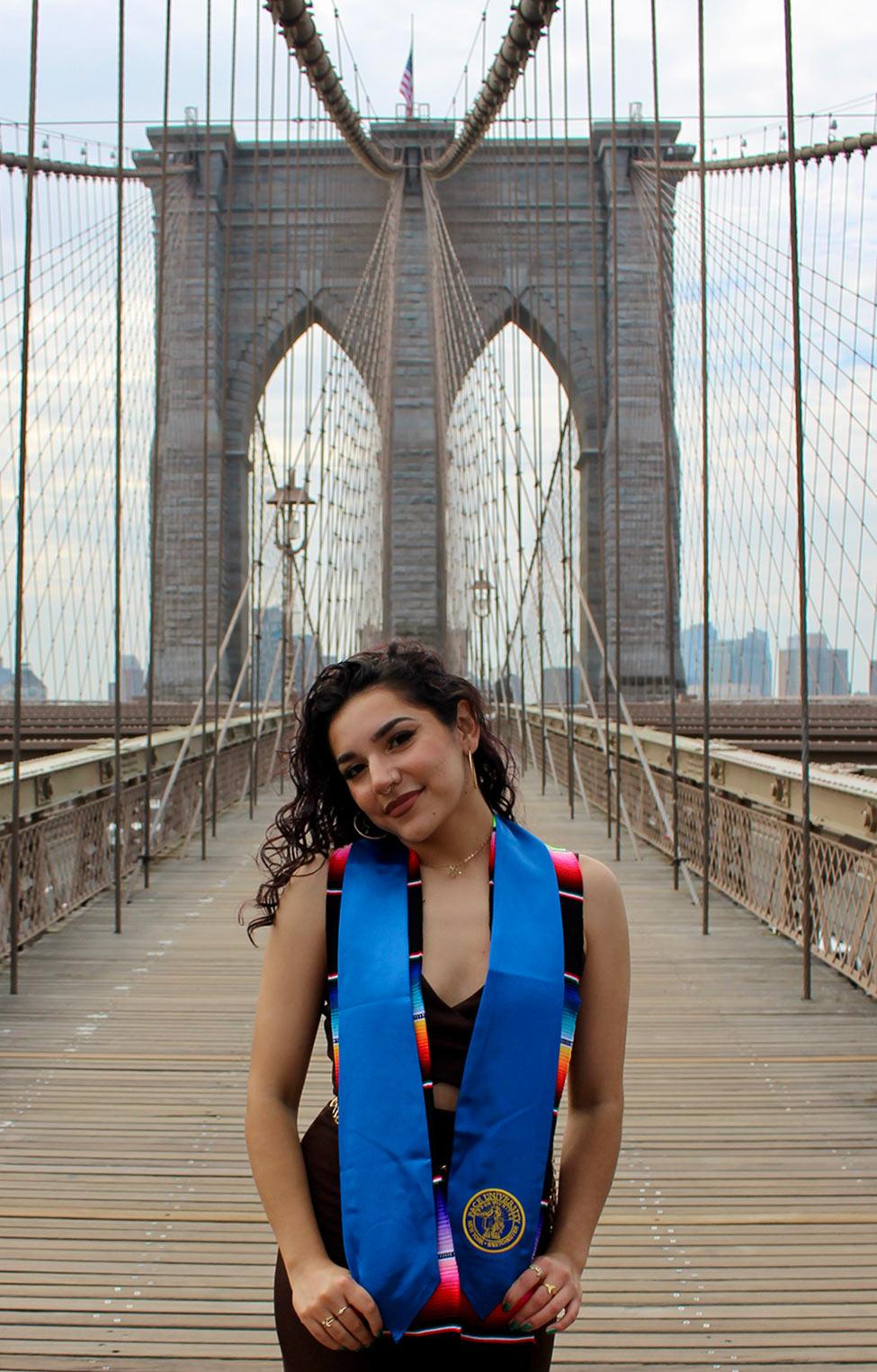 Female Publishing program alum Alma from Pace University, Gomez Martinez, standing on the Brooklyn Bridge