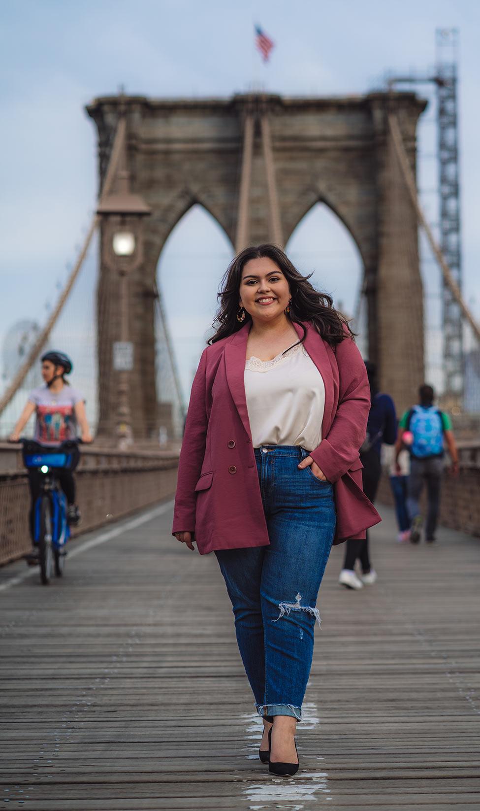 Female Publishing program alum from Pace University, Mae Martinez, standing on the Brooklyn Bridge