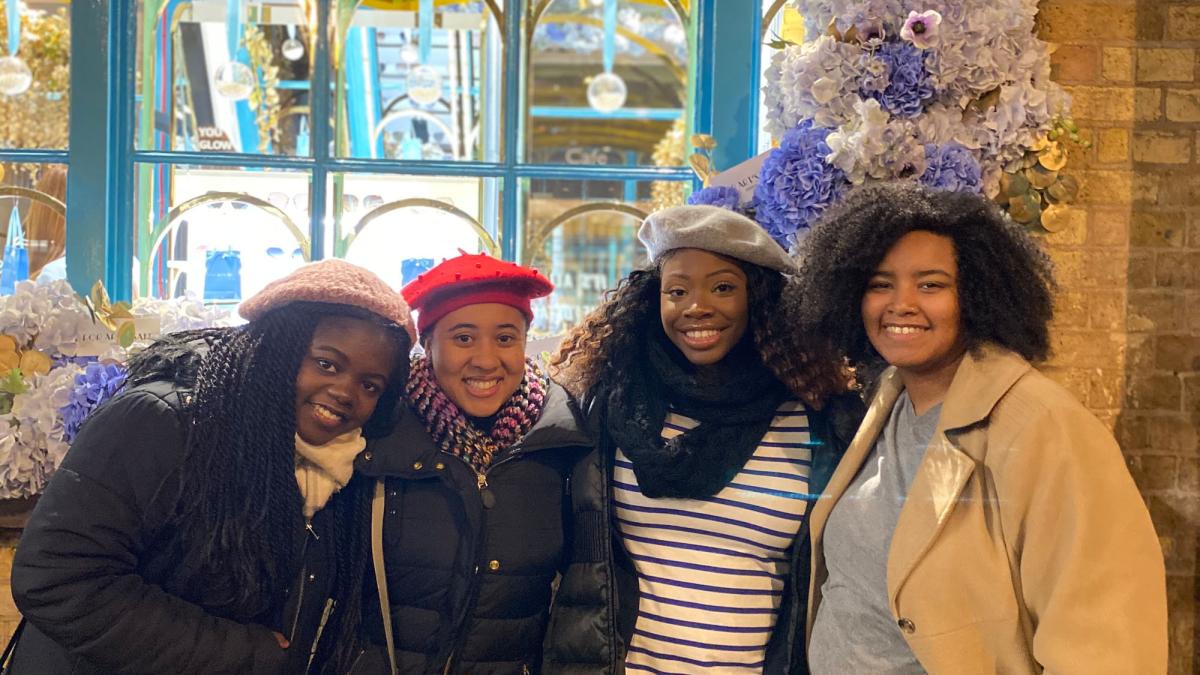 four Pace University Lubin students standing in front of a window in Brussels during a 2019 international field study