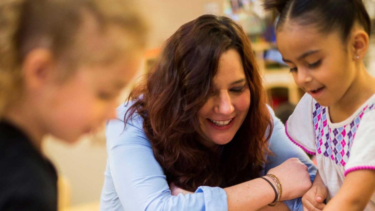 teacher instructing two elementary school students