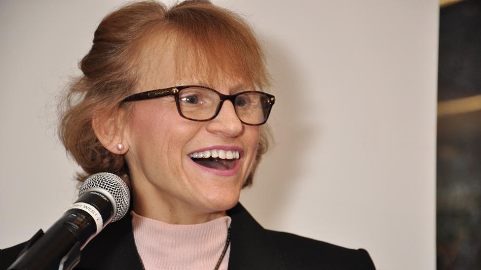 Pace University's Sue Maxam stands in front of a microphone