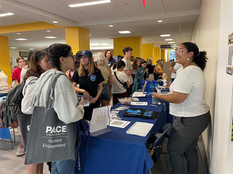 Valentina greets other Pace students at a tabling event