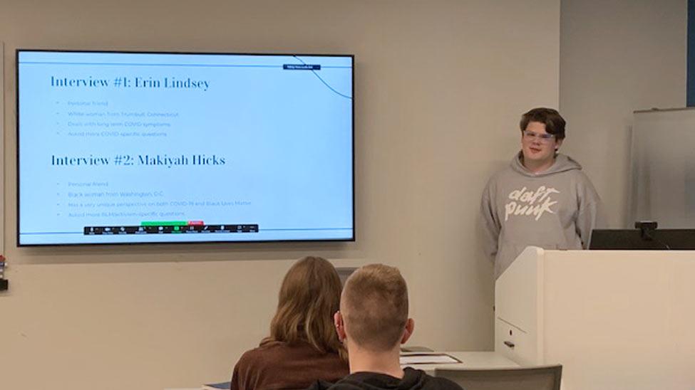 young man at a podium presenting a powerpoint presentation