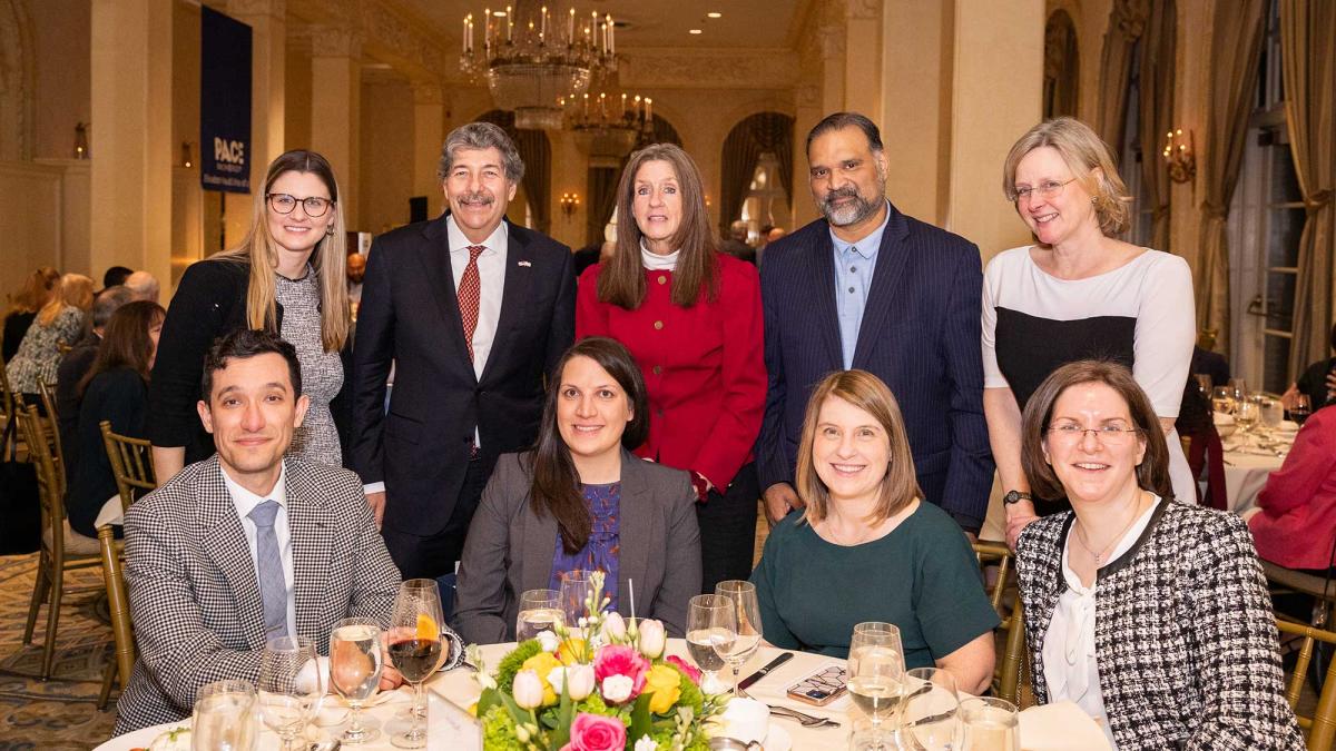 Elisabeth Haub School of Law alumni gathered around a table at an events