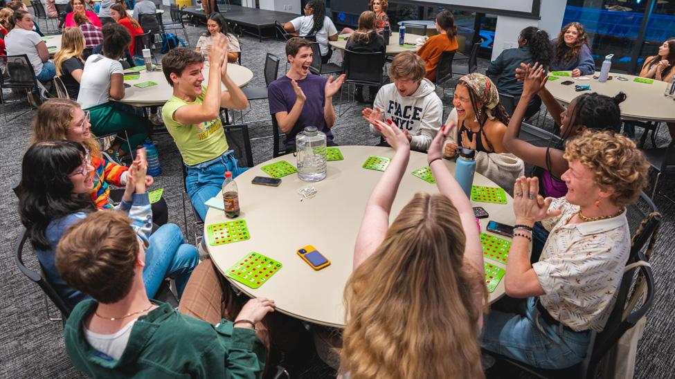 Students playing BINGO at a table.