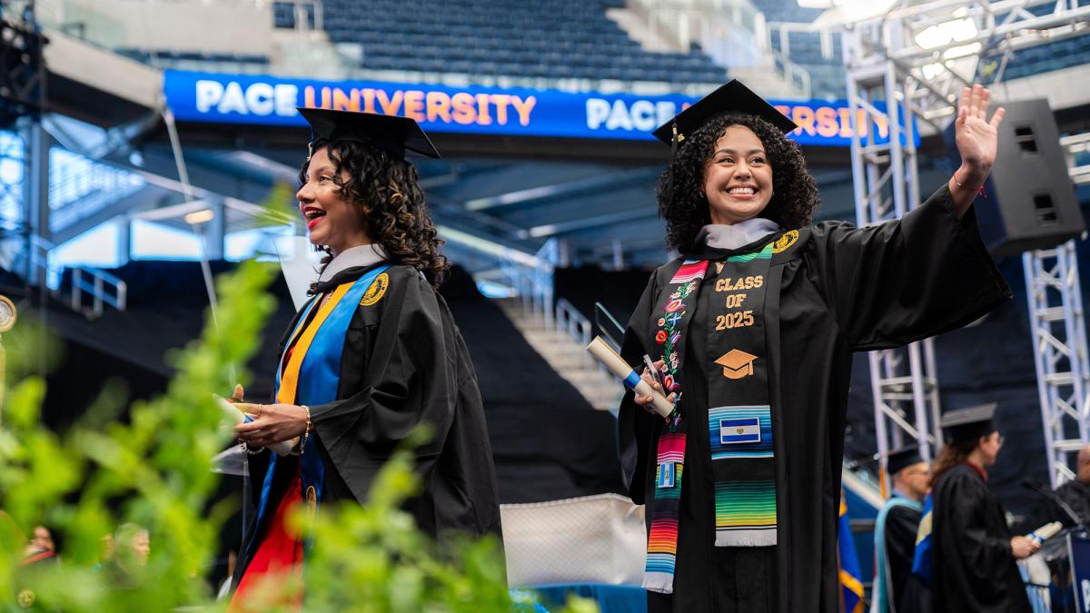 Pace University 2025 graduates walking across the commencement stage.
