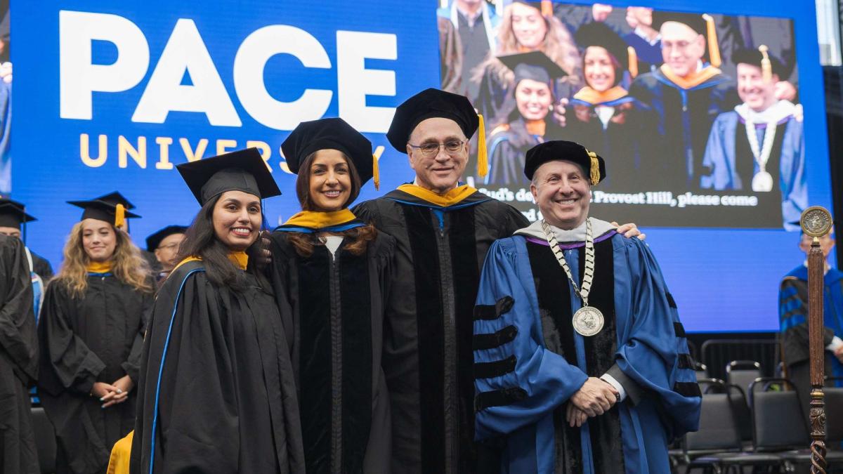 Lolita Tiwari, Anjali Sud, Provost Jonathan Hill, and President Marvin Krislov on stage at Pace University commencement 2025