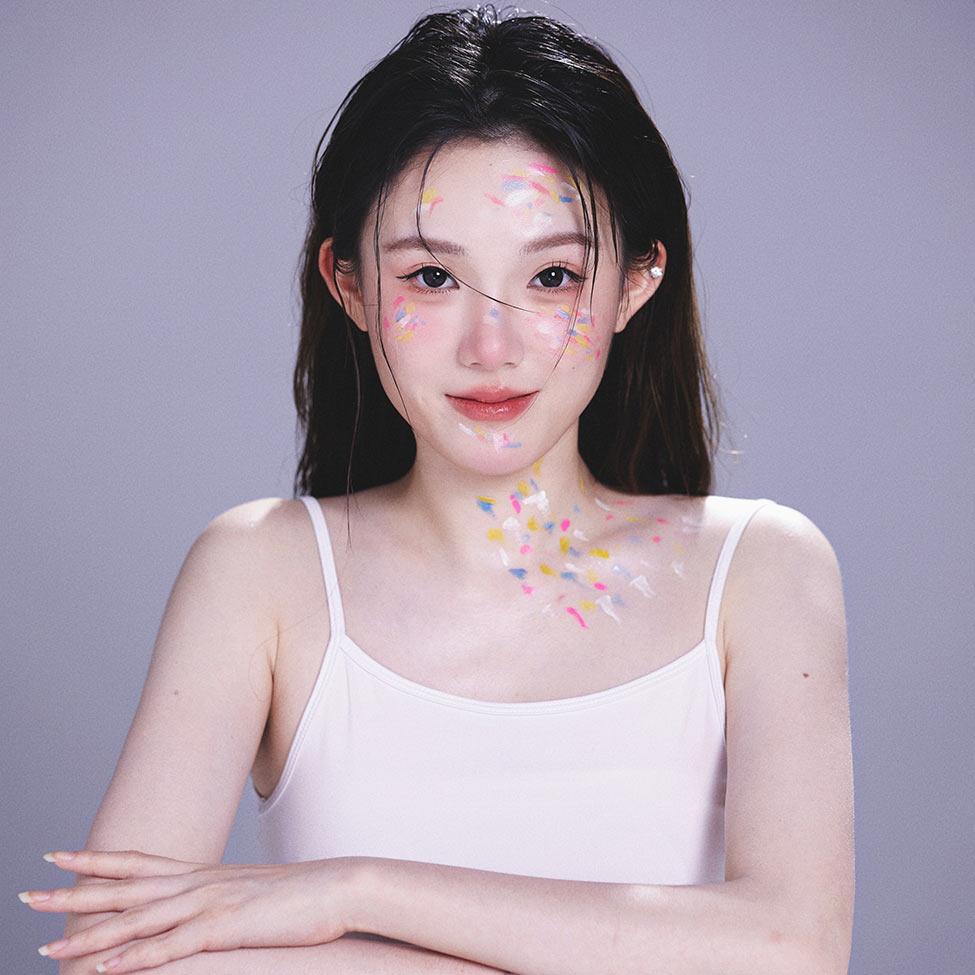 Pace student Yawen Chen looks at the camera with artistic paint splashed on her