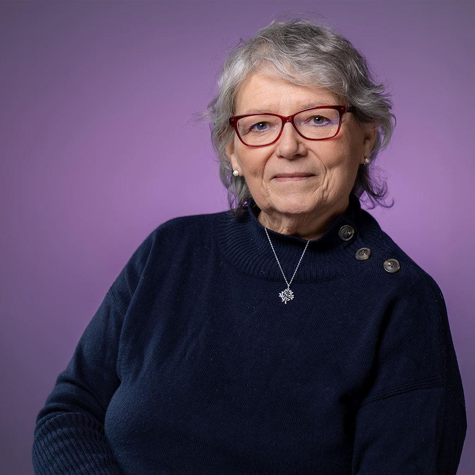 Joyce Malyn-Smith is pictured in front of a purple background 