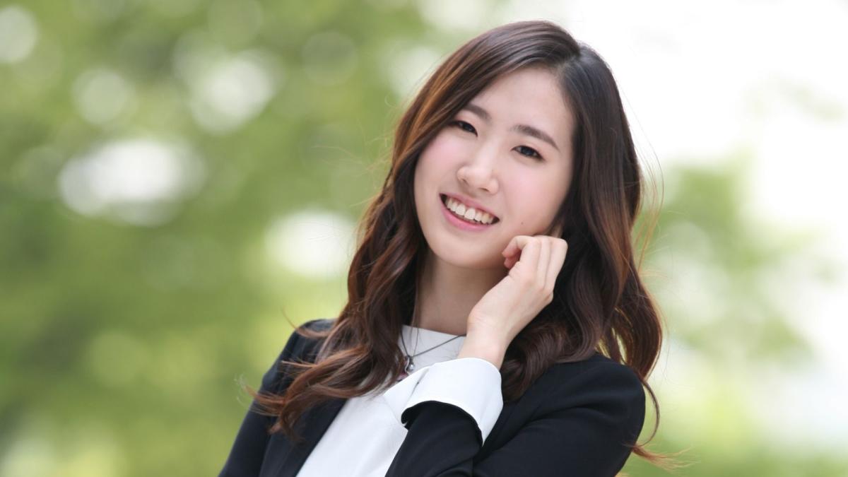 Seidenberg professor Hyunkyung Lee posing for a photo in front of a tree.