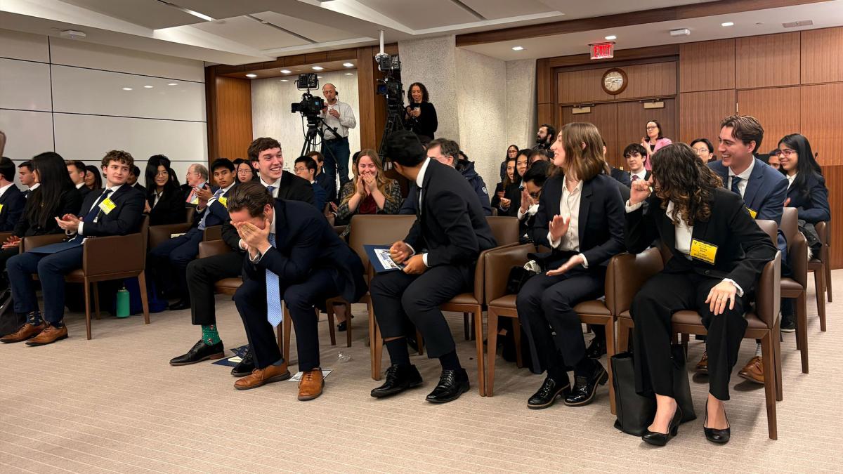 Pace University Federal Reserve Challenge Team reacting to the win in a room with their challengers