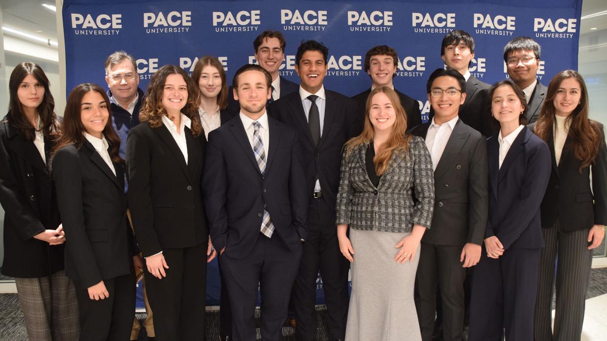 Pace University Federal Reserve Challenge Team winners standing together with Pace media banner in background