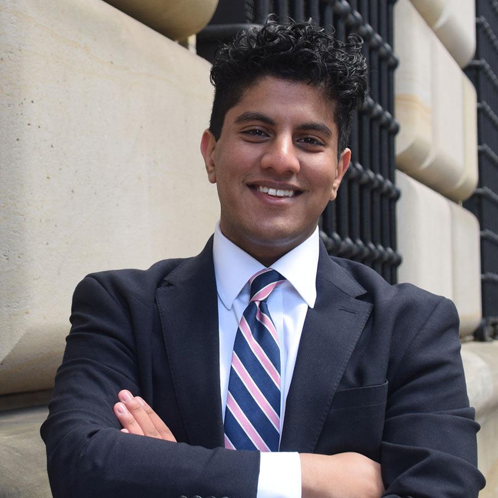 Pace University student Suraj Sharma in a suit with his arms crossed