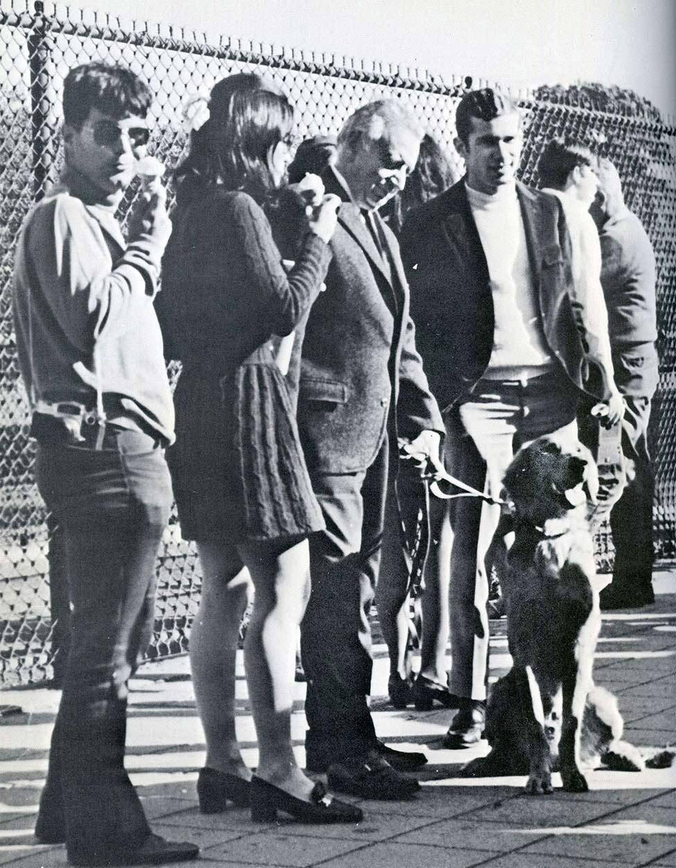 Black and white image of Dr. Mortola and his Irish Setter surrounded by Pace students in 1969.