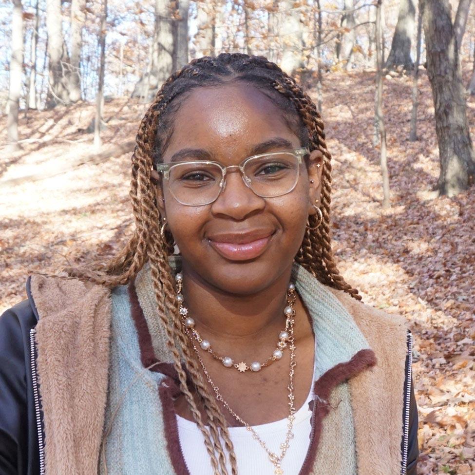 Pace University Economics student Shaniah James with leaves behind her