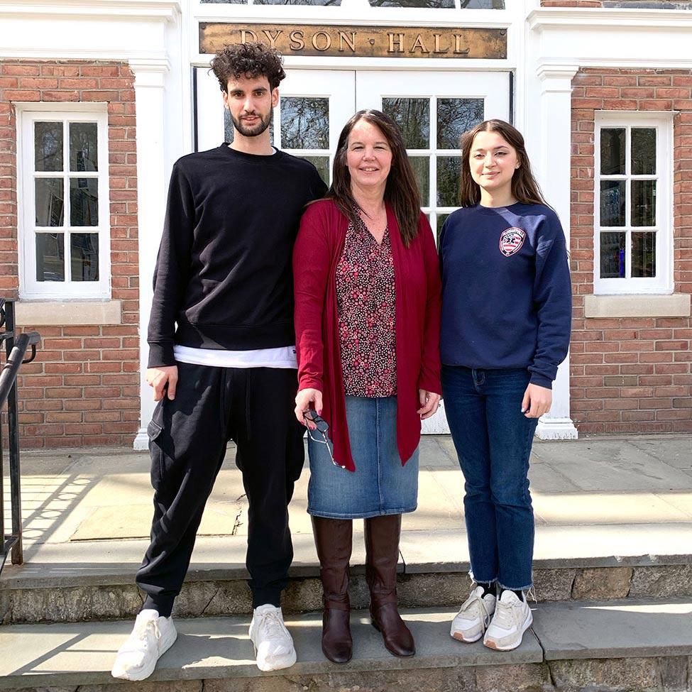 Pace University's Biology Professor Nancy Krucher standing on the steps in front of Dyson Hall with students Michael Feretti and Anastasiia Vaska who assisted in cancer treatment resistance research