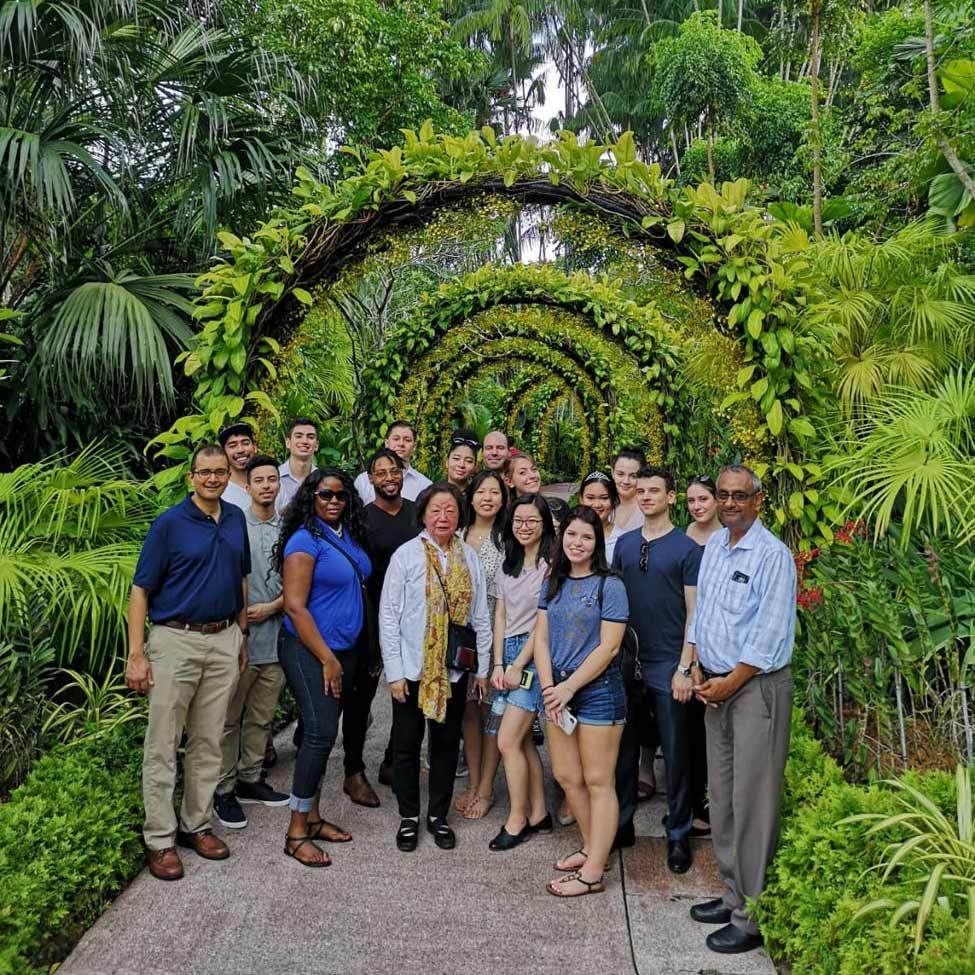 group of Lubin students standing with Prof. Gopalakrishna in a tropical garden in Singapore 