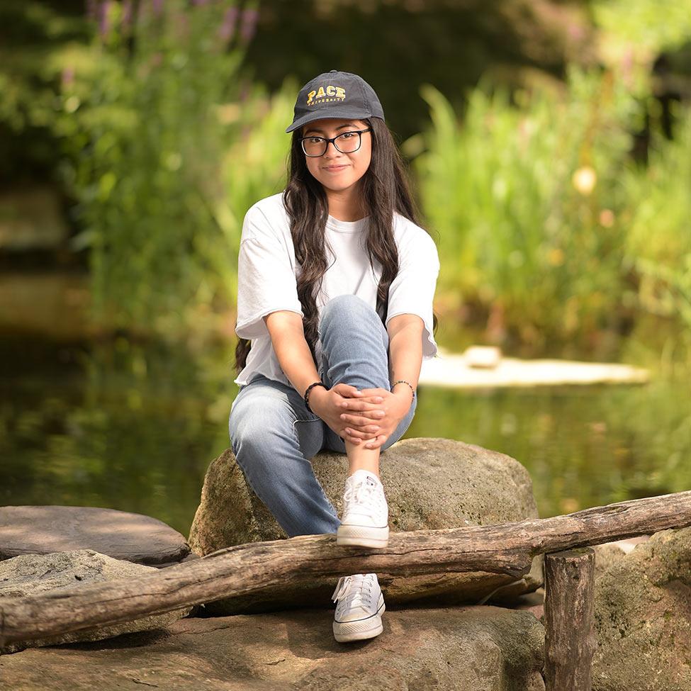 Pace University student Yese Erazo-Tequianes sits in a nature setting
