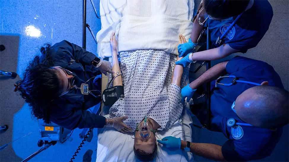 Overhead look at Pace students working on a medical mannekin.