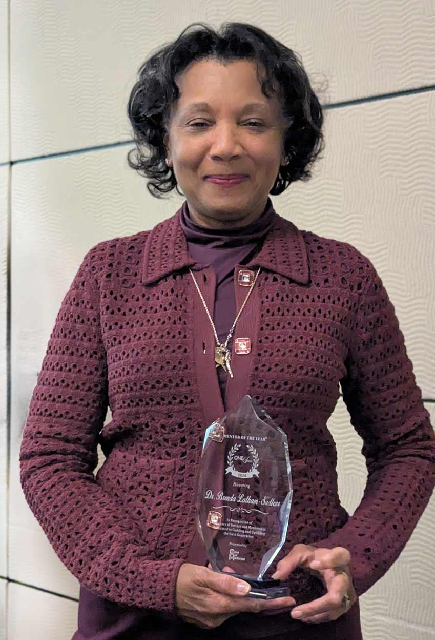 Brenda Latham-Stadler '78 holding an award.