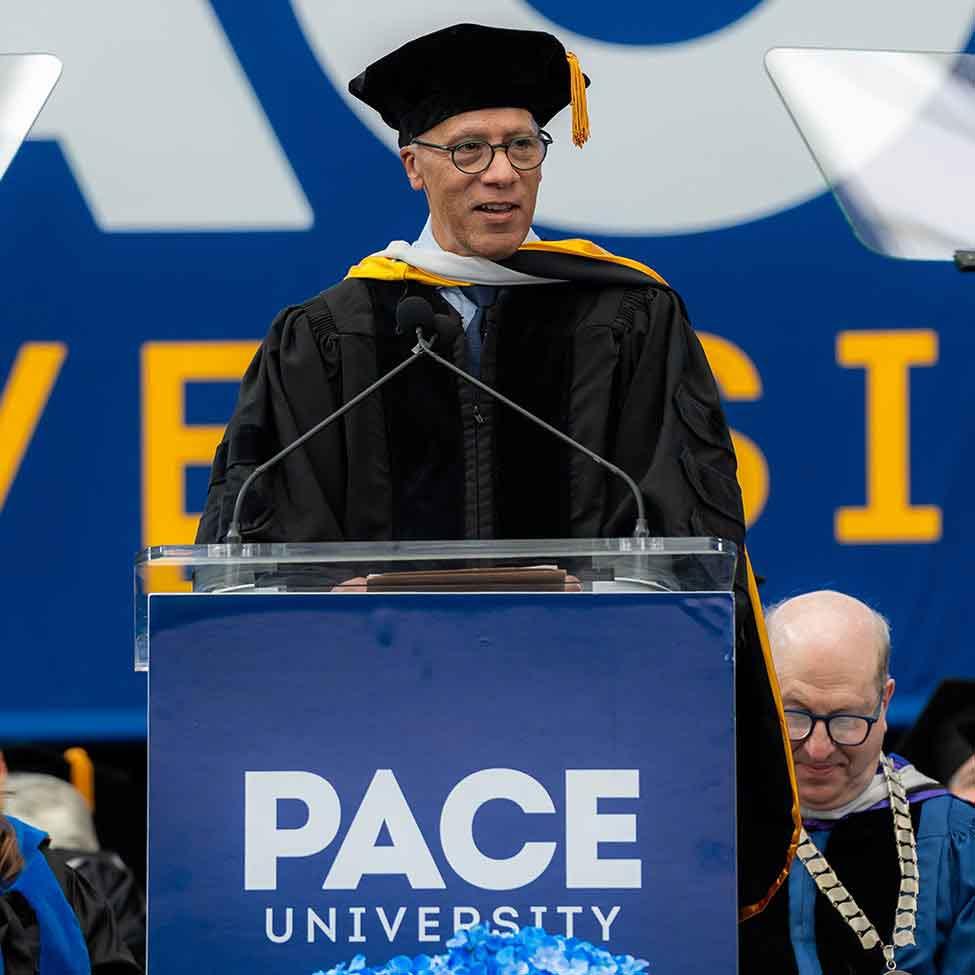 NBC anchor Lester Holt stands at the front of Pace University's Commencement stage