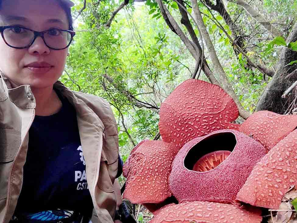 Jeanmaire Molina, PhD, posing in the field with the Rafflesia.