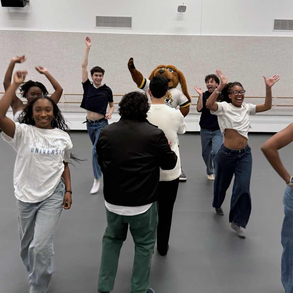 Dancers and T-Bone surrounding photographers in a studio.