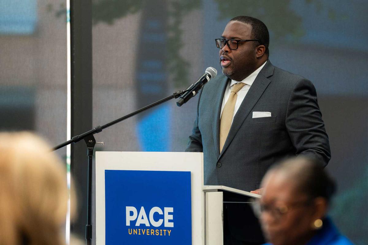 Vincent Clark at a podium speaking into a microphone.